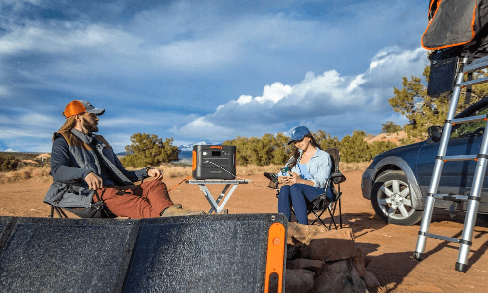 Jackery Explorer power station on a camping trip charging lantern and phone